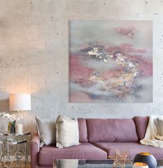 a living room filled with furniture and a painting hanging on the wall above it's coffee table