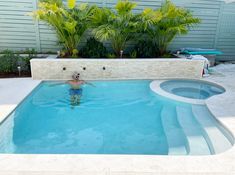 a man is swimming in a pool surrounded by plants