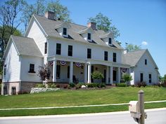 a large white house sitting on the side of a road