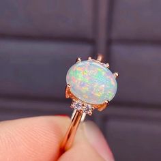 An Elegant and Romantic Ethiopian Opal Ring featuring a shimmering, iridescent opal 8x6 mm accented by sparkling brilliant round diamonds. The ring is handcrafted from 14K Rose gold. As an engagement ring, opals are a perfect representation of the unique spark and fire of your relationship, and their non-replicable nature is a huge draw for those that want a truly one-of-a-kind ring Custom Order: This Ring is offered in different sizes, gold color and the central stone can be upgraded/downgraded Fine Jewelry Ethiopian Opal Ring As Gift, Ethiopian Opal Fine Jewelry Ring, Ethiopian Opal Ring For Wedding, White Ethiopian Opal Ring For Promise, White Ethiopian Opal Ring Fine Jewelry, White Ethiopian Opal Promise Ring, Oval Cabochon Opal Wedding Ring, White Ethiopian Opal Ring For Wedding, White Ethiopian Opal Wedding Ring