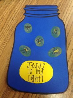 a blue plastic bottle with yellow and green stickers on it sitting on top of a wooden table