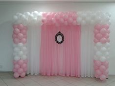 a pink and white backdrop with balloons on the wall for a party or wedding reception