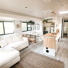 a living room filled with furniture next to a kitchen and dining area in a mobile home