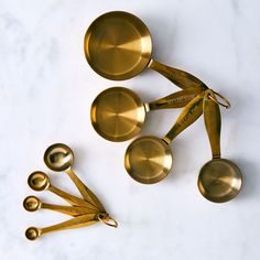 brass measuring spoons and measuring spoons on a marble surface