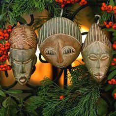 two masks are hanging on a wreath with berries