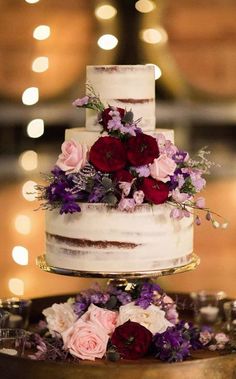 a three tiered cake with flowers on top