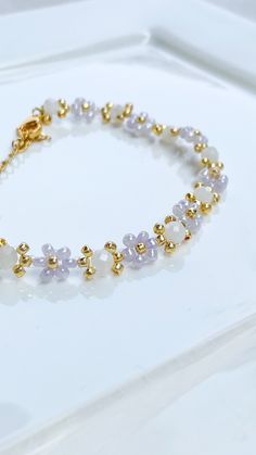 Dainty lilac daisy bracelet made with moonstone gems for her🌜Perfect as a gift for someone else or yourself! The bracelet is secured with a coated stainless steel lobster clasp and has an adjustable length of approx 15.5 - 20.5. If you need any other measurements, please feel free to contact me :) While I make my jewelery with a lot of care, to ensure the longevity of your piece I advise to: - remove when showering, taking a bath or swimming. - avoid direct contact with perfumes, lotions and ot Beaded Daisy Bracelet, Beaded Daisy, Daisy Bracelet, Jun 2023, Floral Bracelet, Flower Bracelet, Beaded Jewelry Diy, Bracelet Gift, Bracelet Making