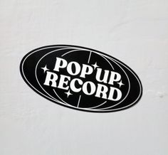 a black and white sticker with the words pop up record on it's side