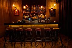 a dimly lit bar with stools in front of it