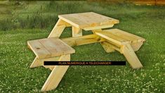 a wooden picnic table sitting on top of a lush green field