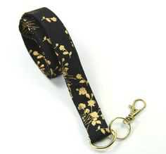 This cute lanyard has gold flowers on black. It is perfect for any occasion. You can leave me a convoy if you need a different size. You can have a wardrobe of lanyard to match your outfit. This lanyard is made of soft 100% cotton fabric to give a comfortable feel around your neck. This lanyard is easy to take care. You can spot clean and throw in a washer and hang dry. If you want you can iron and it is ready to use. These lanyards are perfect if you have metal allergy. Each of these lanyards w Adjustable Black Lanyards For Personal Use, Black Lanyard With Key Leash As Gift, Black Lanyard With Key Leash For Personal Use, Cute Lanyard, Cute Lanyards, Black Lanyard, Fabric Lanyard, Golden Flower, Have Metal