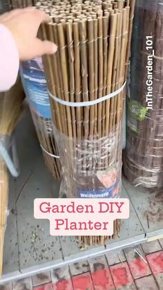 a person is picking up some plants in a store with the words garden diy planter on it