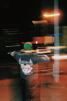 a skateboarder is standing on the street at night with his arms in the air