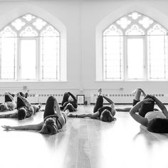 a group of women laying on the floor in a yoga pose with their hands behind their heads