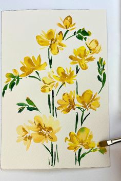 a watercolor painting of yellow flowers on white paper with a gold paint brush next to it