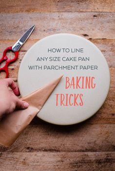 someone is cutting out a cake pan with parchment paper and scissors to make it look like they are baking tricks