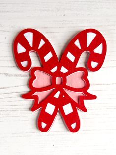 a red and white paper cut out of candy canes on top of a wooden table