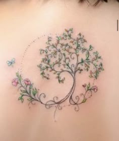 a woman's back with a tree tattoo on it