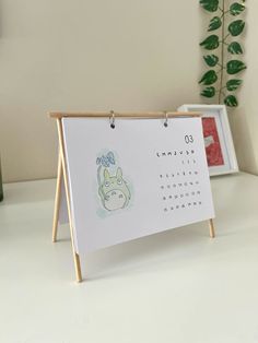 a calendar on a wooden easer next to a potted plant