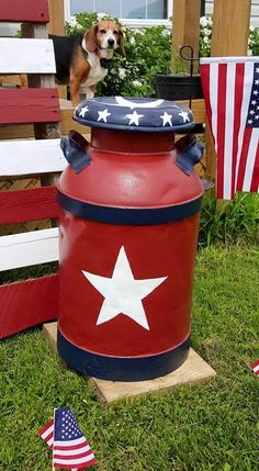 a red, white and blue fire hydrant with a dog standing next to it