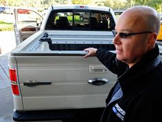 a man in sunglasses is looking at the back of a truck