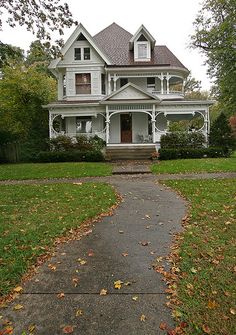 a large white house sitting on top of a lush green field