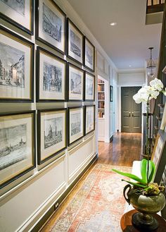 a hallway with many framed pictures on the wall