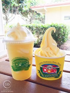 two plastic cups filled with ice cream sitting on top of a wooden table