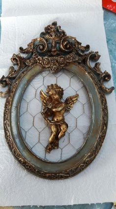 an ornate gold frame with a cherub on it