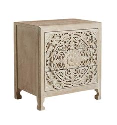 a white wooden cabinet with carvings on it