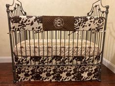 a black and white crib with a monogrammed blanket on the bottom rail