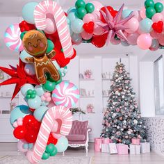 a christmas tree decorated with candy canes, balloons and a gingerbread man hanging from the ceiling