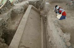 a woman kneeling down in front of an old bathtub that has been dug into the ground