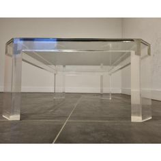 an acrylic table in the middle of a room with tile flooring and white walls