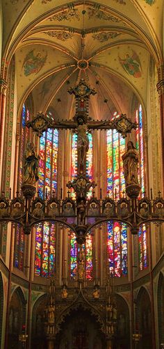 the inside of a church with stained glass windows and chandelier hanging from the ceiling