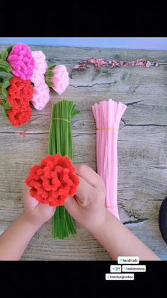 someone is making flowers out of crochet yarn and yarnsticks on the table