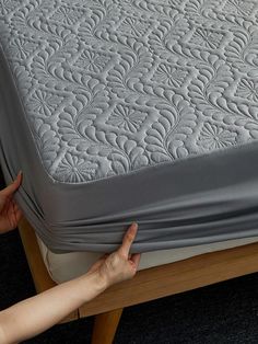 the mattress is being pushed up by someone's hand on top of it,