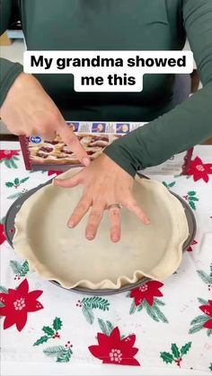 a woman is holding her hand over a pie crust in front of a christmas themed table cloth