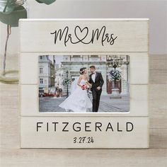 a wedding picture frame with the words mr and mrs written on it, next to a potted plant