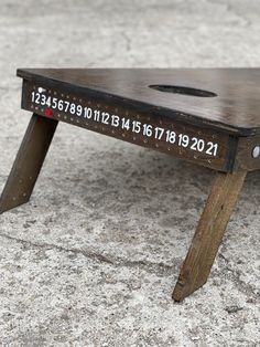 a small wooden bench with numbers on it