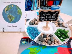 there is a plate with rocks in it and a sign that says explore at the loose parts table