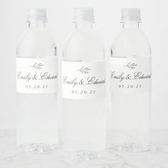 three clear water bottles with labels on them