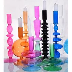 there are many different colored candles and vases