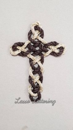 a crocheted cross is shown on a white surface