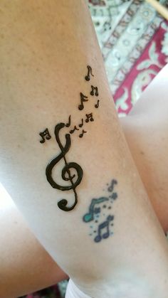 a woman's arm with music notes on it and the word music written in cursive writing