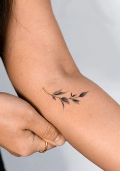 a woman's arm with a small tattoo on the left side of her arm