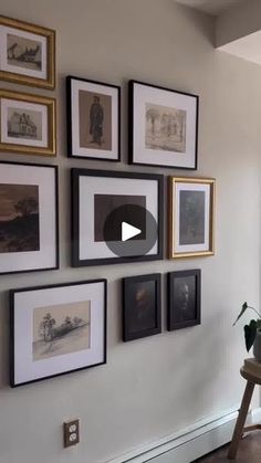 a living room with pictures hanging on the wall and a table in front of it