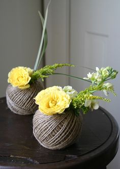 two vases with yellow flowers are sitting on a table