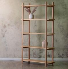 a wooden shelf with two vases on it