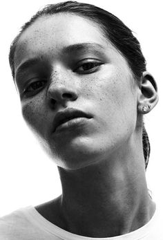 a black and white photo of a woman with freckles